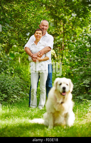 Älteres Paar mit golden Retriever Hund als Haustier in ihrem Garten Stockfoto