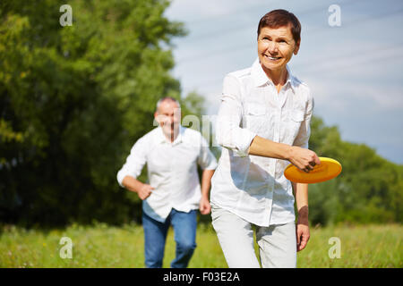 Alte Frau und Mann zusammen spielen Frisbee im Sommer in der Natur Stockfoto