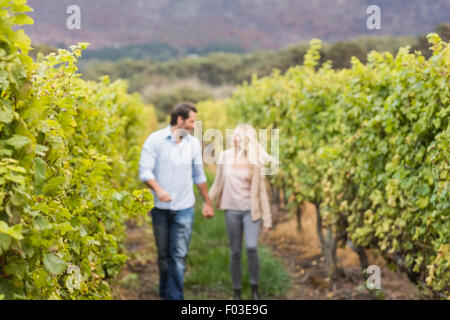 Junge glückliche Paar zu Fuß nebeneinander während Hand in Hand Stockfoto