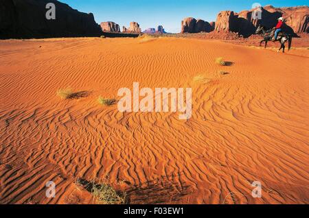 Gips-Creek und Spearhead Mesa, Mann auf dem Pferd in der Wüste, Monument Valley, Arizona und Utah, Vereinigte Staaten von Amerika. Stockfoto