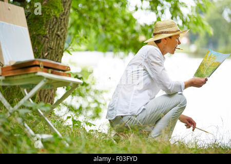 Beautiful senior Woman Gemälde Bild in der Natur im Sommer Stockfoto