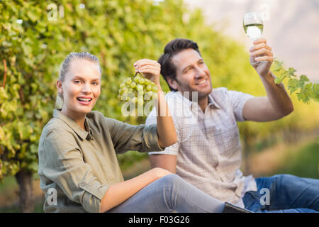 Zwei junge glücklich Winzer mit einem Glas Wein und Trauben Stockfoto