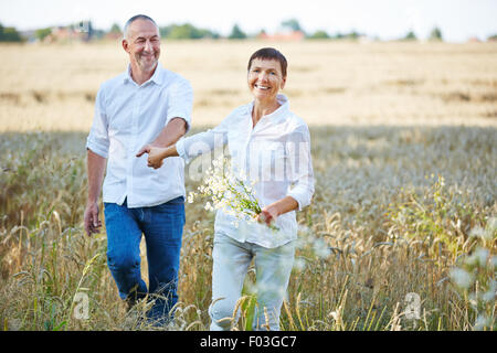 Älteres Paar mit Blumen, Wandern in der Natur im Sommer Stockfoto