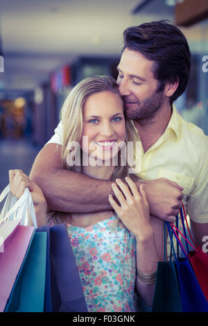 Lächelnde Frau wird von ihrem Freund auf Stirn geküsst Stockfoto