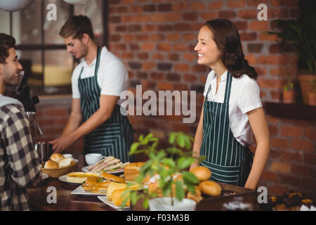 Hübsche Kellnerin mit einem Kunden sprechen Stockfoto