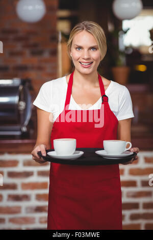 Hübsche Kellnerin hielt ein Tablett mit Kaffee Stockfoto