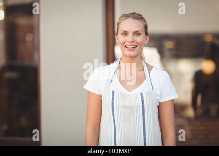 Blonde hübsche Kellnerin lächelnd Stockfoto
