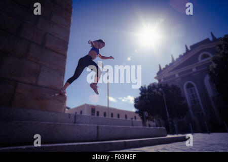 Sportliche Frau, die von der Treppe springen Stockfoto