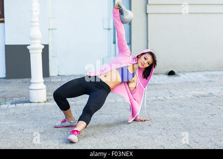 Sportliche Frau Ausübung türkische aufstehen mit kettlebell Stockfoto
