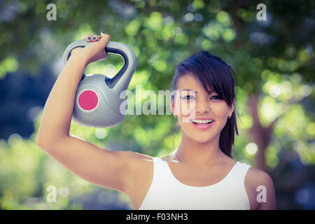 Porträt der lächelnde athletische Frau Kettlebell lifting Stockfoto