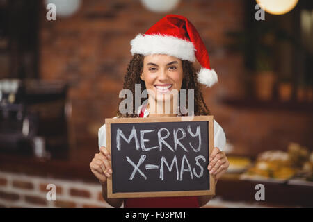 Hübsche Kellnerin mit einer Tafel Frohe Weihnachten Stockfoto