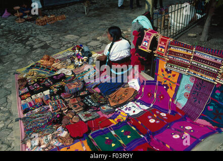 Eine Frau, Verkauf von Stoff und Taschen im Markt San Cristobal de Las Casas, Chiapas, Mexiko. Stockfoto