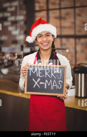 Hübsche Kellnerin mit einer Tafel Frohe Weihnachten Stockfoto