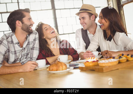 Kaffee und Leckereien genießen Freunde lachen Stockfoto