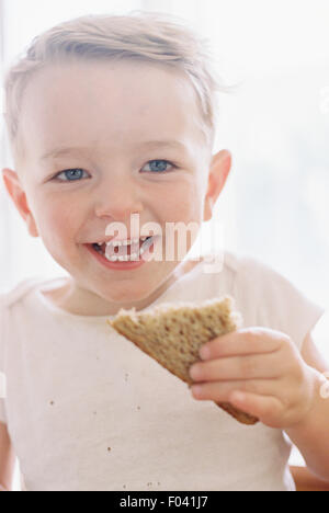 Porträt eines lächelnden jungen ein Sandwich zu essen. Stockfoto