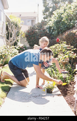 Vater und Tochter in einem Garten Pflanzen einer Blume. Stockfoto