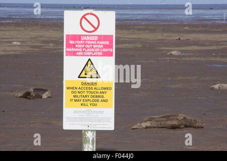 Schilder am Wattenmeer bei Donna Nook Natur Reservat Warnung öffentliche, Gefahren des militärischen schießen und Schutt, UK zu sein Stockfoto