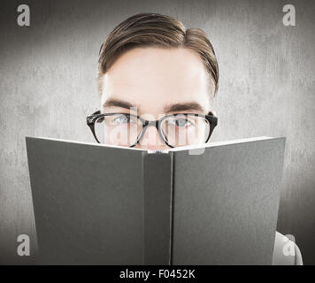 Zusammengesetztes Bild geeky Mannes Blick auf Buch Stockfoto