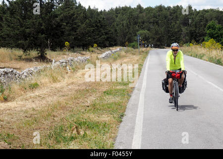 Touren mit dem Fahrrad auf einer Landstraße entlang einer niedrigen Steinmauer Radfahrer Stockfoto