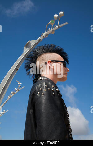 Blackpool, Lancashire, UK. 6. August 2015. Punk Rebellion Festival im Winter Gardens. Ein Zusammenprall der Kulturen an der berühmten küstenstadt Blackpool als Punks die Teilnahme an der jährlichen Rebellion Festival im Winter Gardens kommen Schulter mit traditionellen Urlauber eine Freiheit Mohawk oder Mohican Frisur mit Kopf rasiert zu schultern. Stockfoto