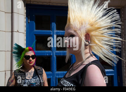 Punks mit mohican mohican Frisur gefärbte Freiheit bei Blackpool, Lancashire, UK. 7. Aug 2015. Punk Rebellion Paar, Festival im Winter Gardens. Ein Zusammenprall der Kulturen an der berühmten küstenstadt Blackpool als Punks, mit Liberty ährentragend Frisuren & Bolzen, Nieten, Nasenring, Mode, Frau, Haar, Haut. Frauen die Teilnahme an der jährlichen Rebellion Festival im Winter Gardens kommen Schulter mit traditionellen Urlauber zu schultern. Credit: MediaWorldImages/Alamy leben Nachrichten Stockfoto