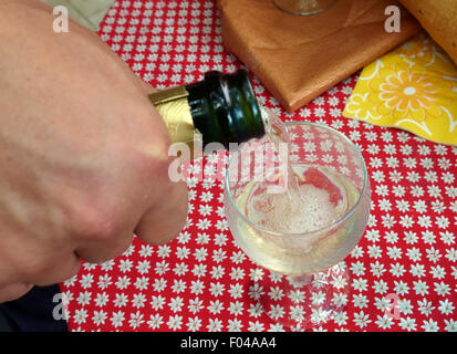 Gießen ein Glas Champagner auf einer Party in Frankreich Stockfoto