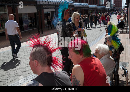 Punks mit mohican Mohican gefärbt (Liberty spikes) Frisur bei Blackpool, Lancashire, UK. 7. Aug 2015. Der Punk Rebellion Festival im Winter Gardens. Ein Zusammenprall der Kulturen an der berühmten küstenstadt Blackpool als Punks die Teilnahme an der jährlichen Rebellion Festival im Winter Gardens kommen Schulter mit traditionellen Urlauber zu schultern. An diesem Wochenende berühmten Rebellion Festival gefeiert wurde "eine tolle Veranstaltung" mit Hoteliers und Bars profitieren von einem Anstieg der Besucherzahlen. Credit: MediaWorldImages/Alamy leben Nachrichten Stockfoto
