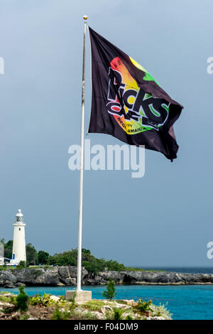 Negril, Jamaika - 30. Mai 2015: Ricks Cafe Flagge auf der Klippe und Negril Leuchtturm im Hintergrund. Stockfoto