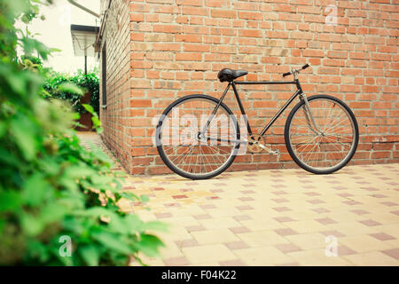 Alten Stil Singlespeed Fahrrad gegen Mauer, getönten Foto Stockfoto