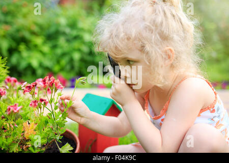 Kleines Mädchen, die Erforschung der Natur mit einer Lupe Stockfoto