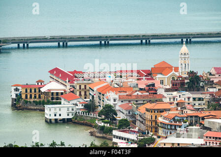 Casco Viejo Historic District Coastal Beltway Panama-Stadt Panama // PANAMA-STADT, Panama — der umstrittene Küstenbeltway (Cinta Costera III) kurvt sich um den historischen Bezirk Casco Viejo in Panama-Stadt, vom Gipfel des Ancon Hill aus gesehen. Der 654 Meter hohe Hügel bietet einen Panoramablick auf die modernen und kolonialen Teile von Panama City, wobei der Pazifik und der Panamakanal in der Ferne sichtbar sind. Casco Viejo, ein UNESCO-Weltkulturerbe aus dem 17. Jahrhundert, steht in krassem Kontrast zur modernen Straße, die über dem Wasser gebaut wurde. Ancon Hill war früher der Administrator Stockfoto