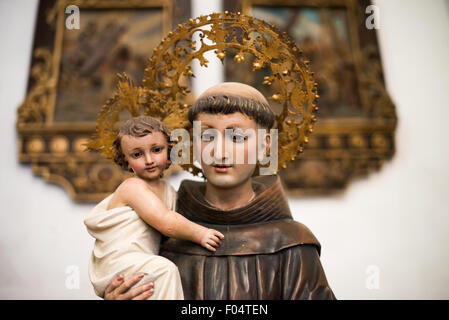 Iglesia San Jose Statue Panama-Stadt Panama | PANAMA-STADT, Panama — Eine Andachtsstatue steht in der Iglesia San José, im Herzen des historischen Viertels San Felipe (Casco Viejo) von Panama-Stadt. Die Kirche wurde von den Augustiner-Eremiten um 1675 erbaut, einer der ersten monumentalen Komplexe, die nach der Neugründung Panamas im Jahr 1673 an ihrem heutigen Halbinselstandort fertiggestellt wurden — eine Verlegung eines Ordens, der sich zuerst in der dem Untergang geweihten Originalstadt im Jahr 1612 niedergelassen hatte. Heute ist sie eine aktive Pfarrei und die zweitmeistbesuchte Kirche im Viertel Casco Viejo, vor allem bekannt für ihren vergoldeten barocken Altar Stockfoto
