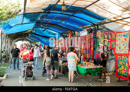 Panamaischer Kunsthandwerksmarkt Casco Viejo Panama-STADT // PANAMA-STADT, Panama — auf einem Touristenmarkt am Ufer von Casco Viejo, der historischen Altstadt von Panama-Stadt, werden bunte gewebte Textilien in lokalen Stilen zum Verkauf angeboten. Casco Viejo, auch bekannt als Casco Antiguo, ist ein UNESCO-Weltkulturerbe, das auf das Ende des 17. Jahrhunderts zurückgeht, nachdem die ursprüngliche Stadt Panama von Piraten zerstört wurde. Das Viertel besticht durch spanische Kolonialarchitektur, enge Kopfsteinpflasterstraßen und lebhafte Plätze. Lokale Handwerker stellen oft traditionelles panamaisches Kunsthandwerk vor, einschließlich Molas (Textilkunst mA Stockfoto