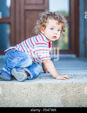 Porträt des 1-jährigen Jungen klettern die Treppe hinunter. Stockfoto