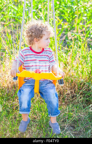 Porträt des 1-jährigen Jungen spielen in einem Schwung. Stockfoto