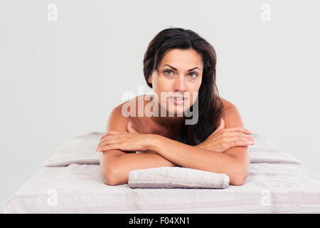Attraktive junge Frau liegend auf der Massageliege in ein Wellness-Center und Blick in die Kamera Stockfoto
