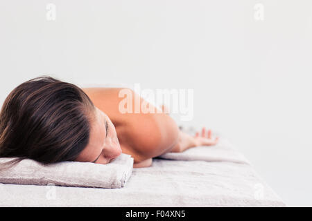 Frau ruht auf Massageliege in ein Wellness-Center, isoliert auf weißem Hintergrund Stockfoto