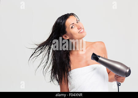 Hübsche junge Frau im Handtuch trocknen ihr Haar auf einem weißen Hintergrund isoliert Stockfoto