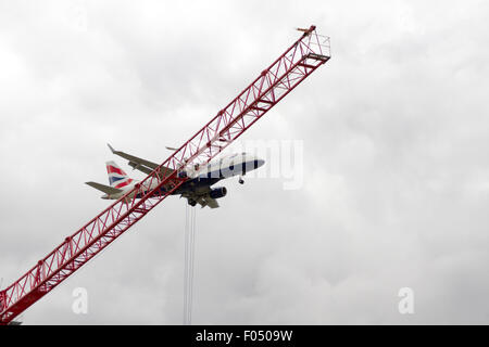 British Airways Airbus A318 G-LCYU landet auf dem Flughafen London City hinter Turmdrehkran auf Galeonen erreichen Entwicklung, Docklands Stockfoto