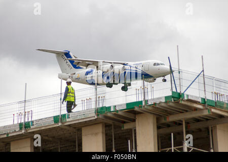 CityJet Dornier 328-110 landet auf dem Flughafen London City hinter Turmdrehkran auf Galeonen erreichen Entwicklung, Docklands Stockfoto