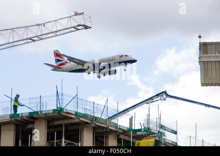 British Airways Airbus A318 G-LCYU landet auf dem Flughafen London City hinter Turmdrehkran auf Galeonen erreichen Entwicklung, Docklands Stockfoto