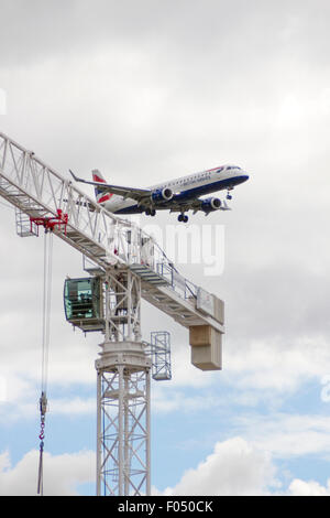 British Airways Airbus A318 Landung am Flughafen London City hinter Turmdrehkran auf Galeonen erreichen Entwicklung, Docklands Stockfoto