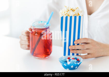 Frau mit Popcorn und Getränken in Mason Glas Stockfoto