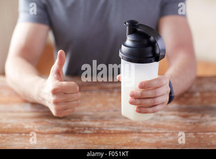 Mann mit Protein shake Flasche Daumen auftauchen Stockfoto