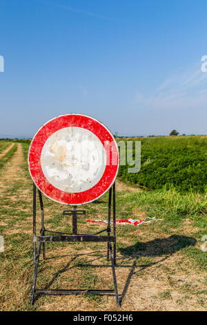 Verkehrszeichen und Landstraßen - zum verblichene Höchstgeschwindigkeit 30 km/h Zeichen ein Zeichen, das Verbot des Zugangs zu den Trail am Ufer eines Flusses Stockfoto