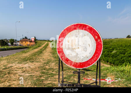 Verkehrszeichen und Landstraßen - zum verblichene Höchstgeschwindigkeit 30 km/h Zeichen ein Zeichen, das Verbot des Zugangs zu den Trail am Ufer eines Flusses Stockfoto