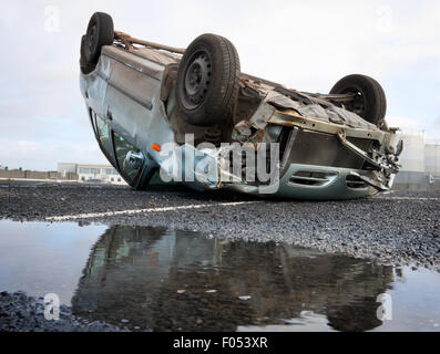 Auto umgedreht nach Verkehrsunfall und Spiegelung im Wasser Stockfoto