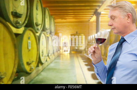 Senior woman riechenden Rotwein im Keller Stockfoto