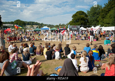 Familien beobachten ein Balanceakt in der Sommersonne von Garküchen und Zelten am Hafen Eliot Festival Cornwall Stockfoto