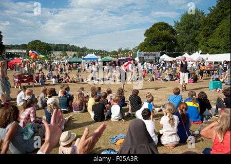 Familien beobachten ein Balanceakt in der Sommersonne von Garküchen und Zelten am Hafen Eliot Festival Cornwall Stockfoto